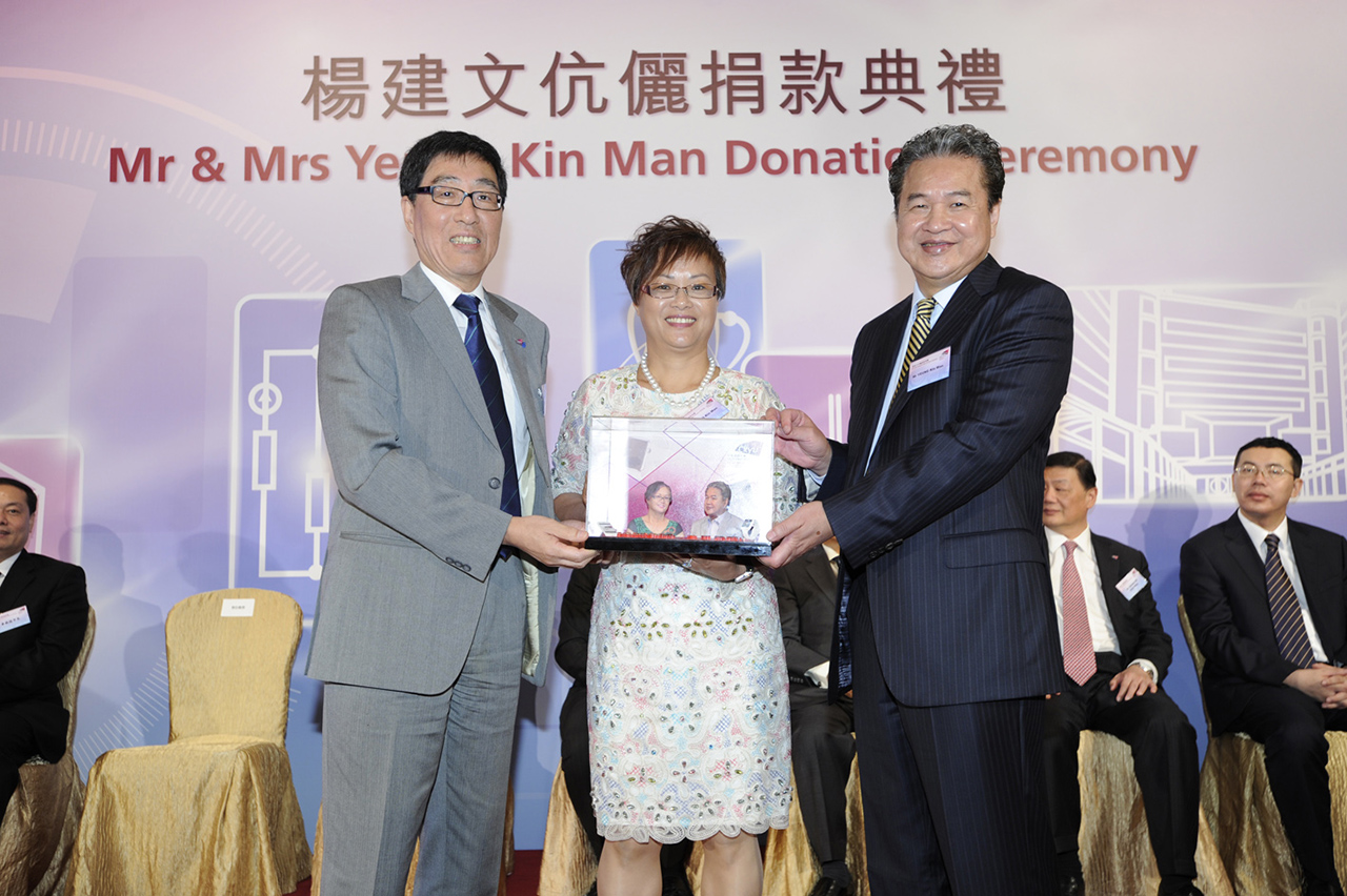 Prof Kuo (left) presents a souvenir to Mr and Mrs Yeung on behalf of CityU