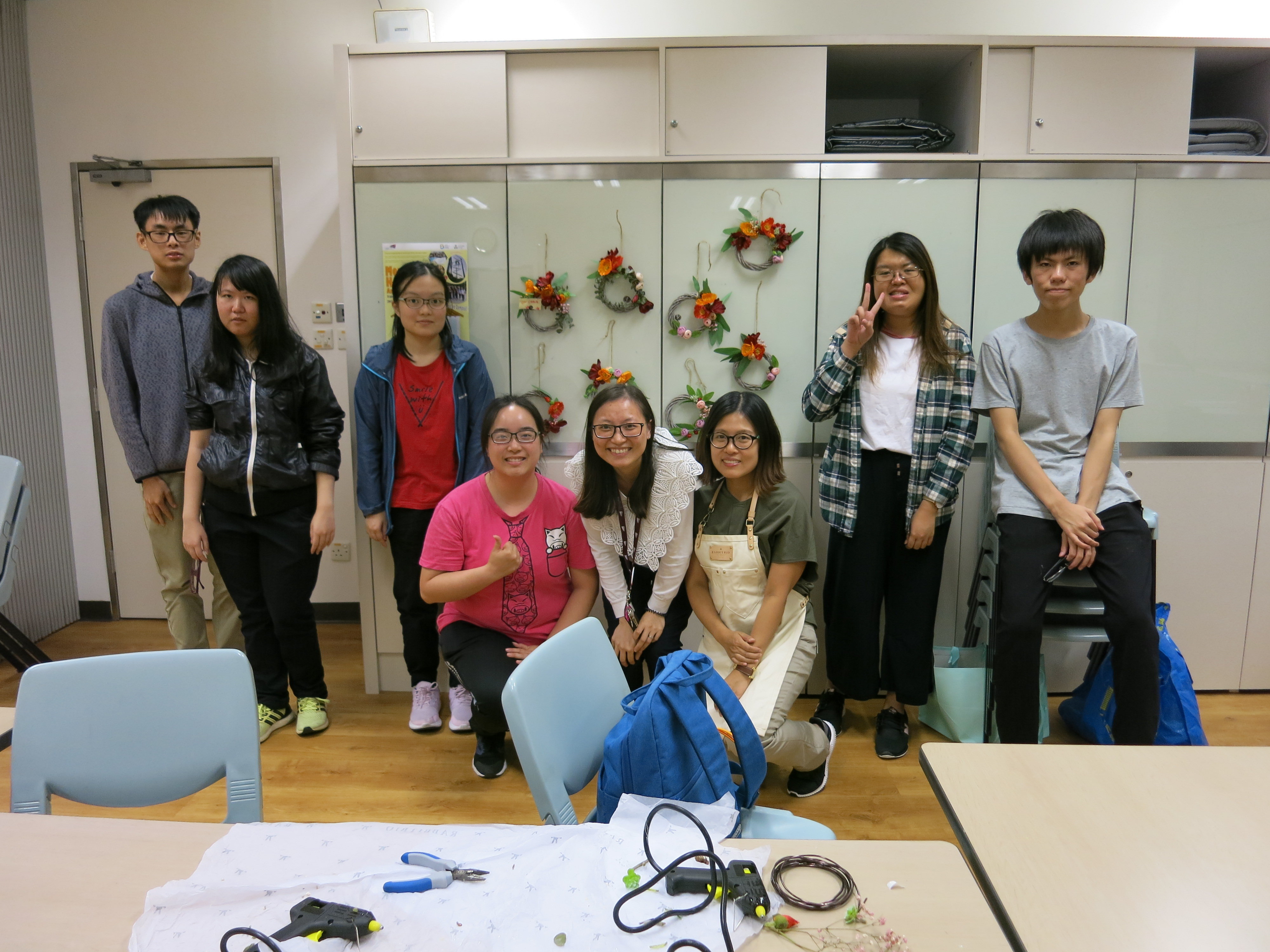 A photo of students and the teacher with their flower wreaths. 