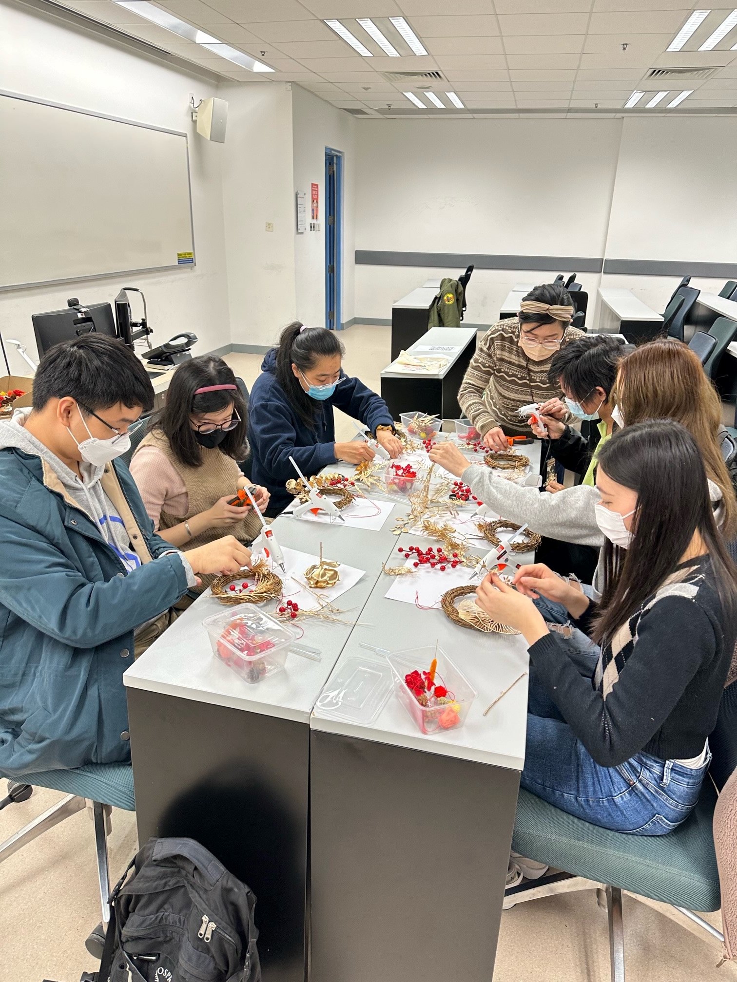 Students are making preserved flower wreath ornaments.學生正制作永生花花圈吊飾