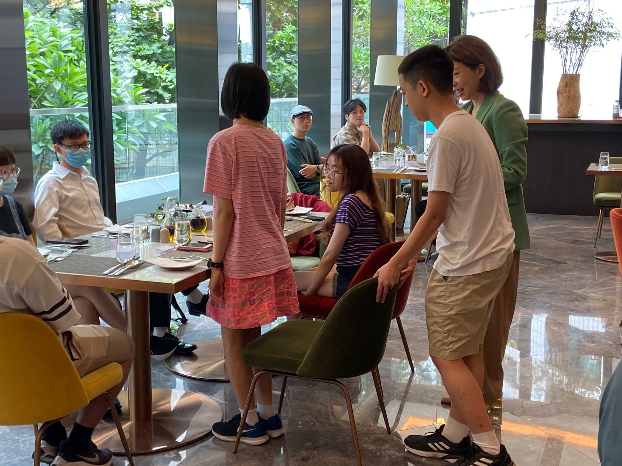 Participants are practicing the etiquette way of pushing a chair.參與者正在練習(xí)推椅子的禮儀方式。
