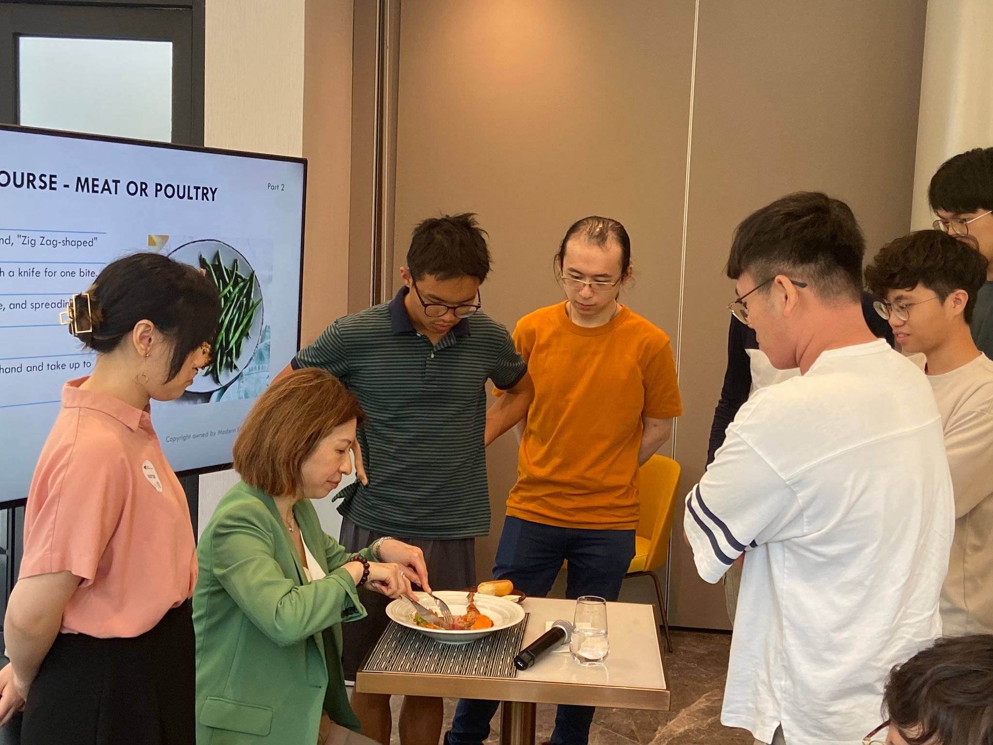 The instructor is demonstrating how to enjoy duck legs elegantly.導師正在示范如何優雅地享用鴨腿。