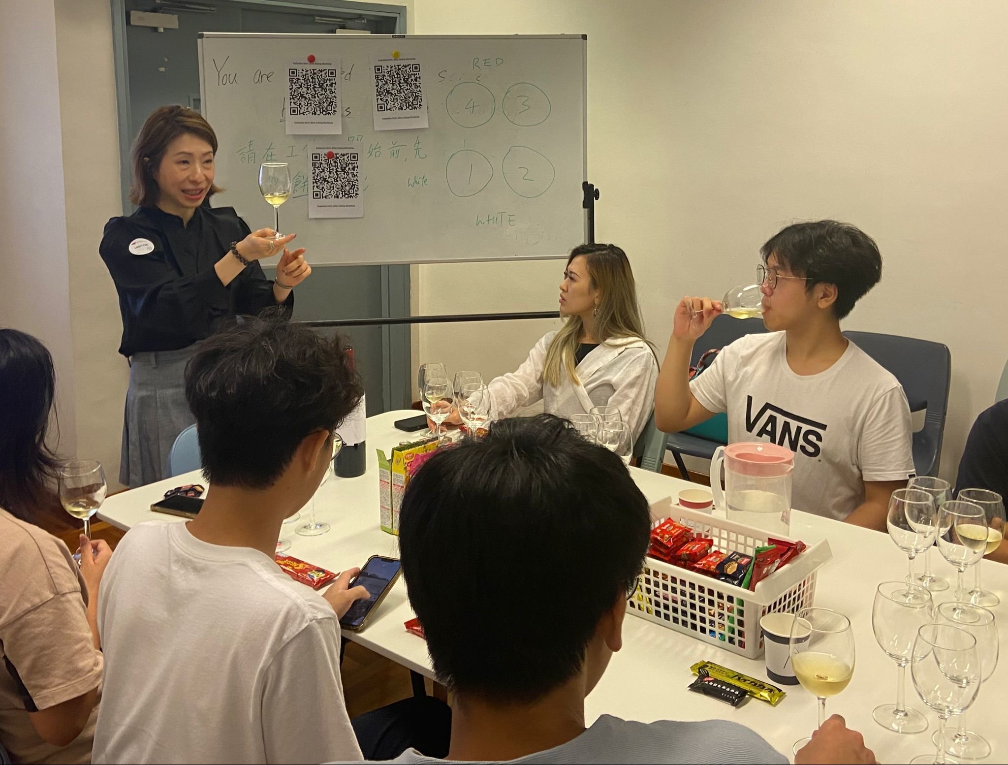 導(dǎo)師正在教如何拿酒杯。Tutor is teaching how to hold a wine glass.