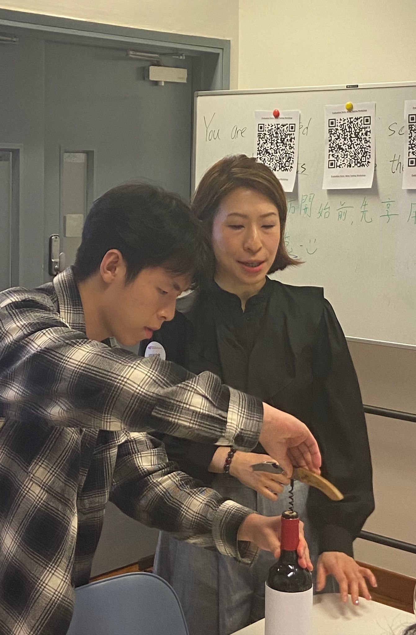 參與者正在學(xué)習(xí)如何打開葡萄酒。Participants are learning how to open wine.