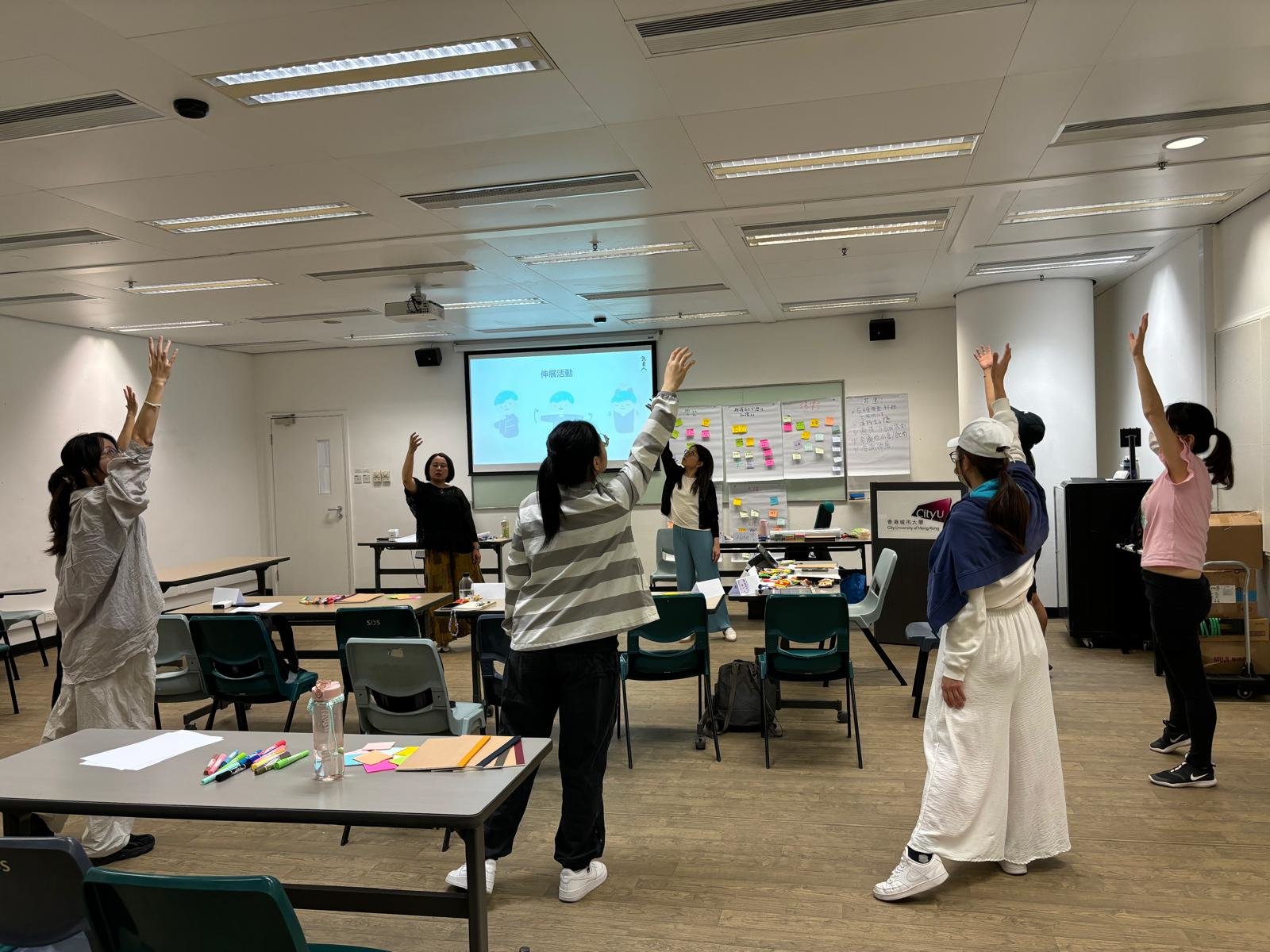 The instructor and the students were doing stretching exercises. 導師和同學們在進行伸展運動。