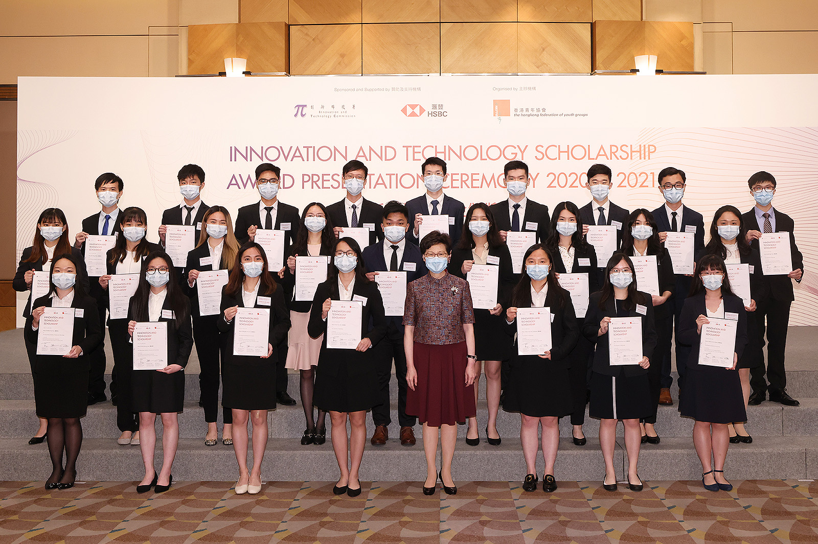 The four CityU awardees, Monica Chan and Harvey Ng (2nd and 5th from left in 2nd row); and Andy Wong and Xavier Yeung (2nd and 3rd from left in 3rd row) received their certificates from the Chief Executive of the HKSAR, Mrs Carrie Lam Cheng Yuet-ngor, at the Innovation and Technology Scholarship Award Presentation Ceremony on 21 June.