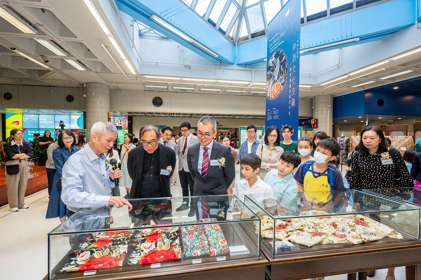 Mr Zheng (left) introduces the artworks showcased at the exhibition to the distinguished guests.